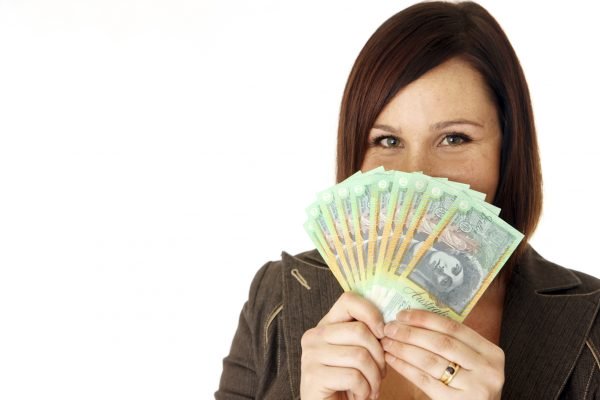 Smiling woman holding a bundle of Australian banknotes
