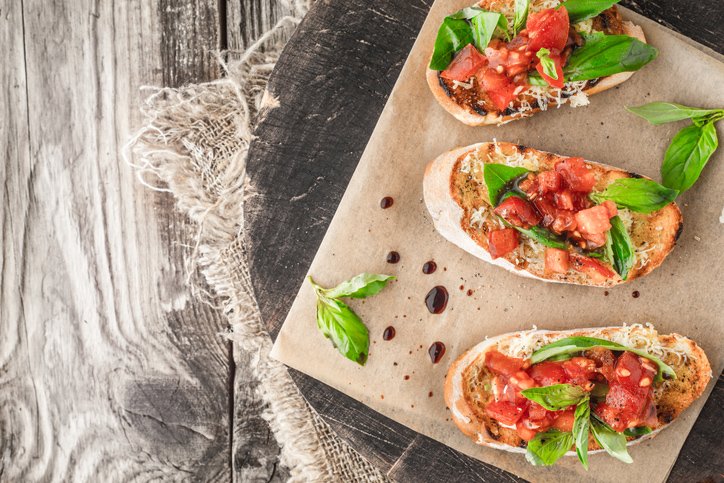 Bruschetta with tomatoes and basil on the wooden board top view horizontal