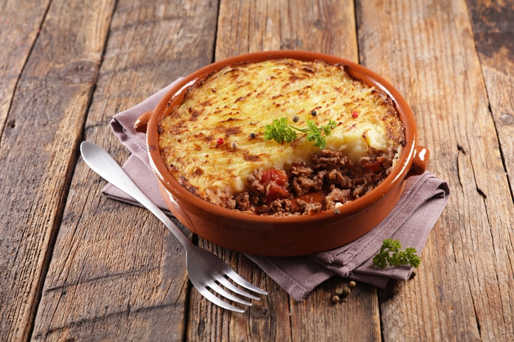 shepherd's pie in red bowl on wooden table